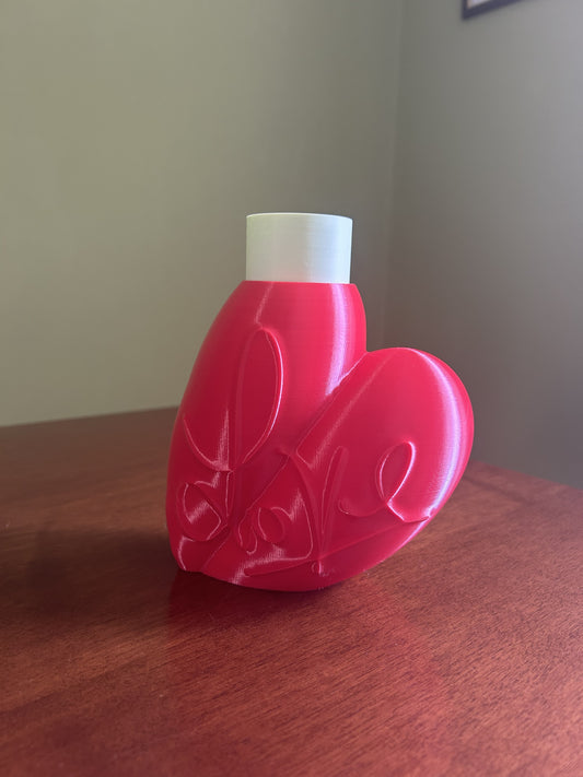 Vaso Cuore in Love stampato in 3D in PLA, design a cuore rosso con tubo porta fiore bianco, vista frontale su tavolo