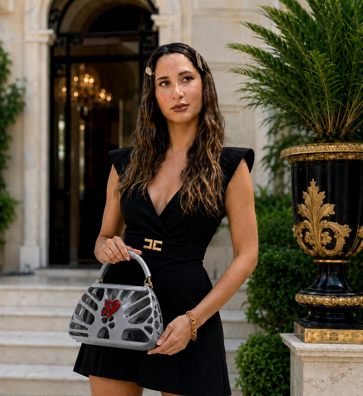 Borsa FDR grigio lucido da donna Fjoccola, borsa a mano dal design 3D originale in PLA Silk, con struttura traforata e cuore rosso, abbinata a un elegante abito nero.