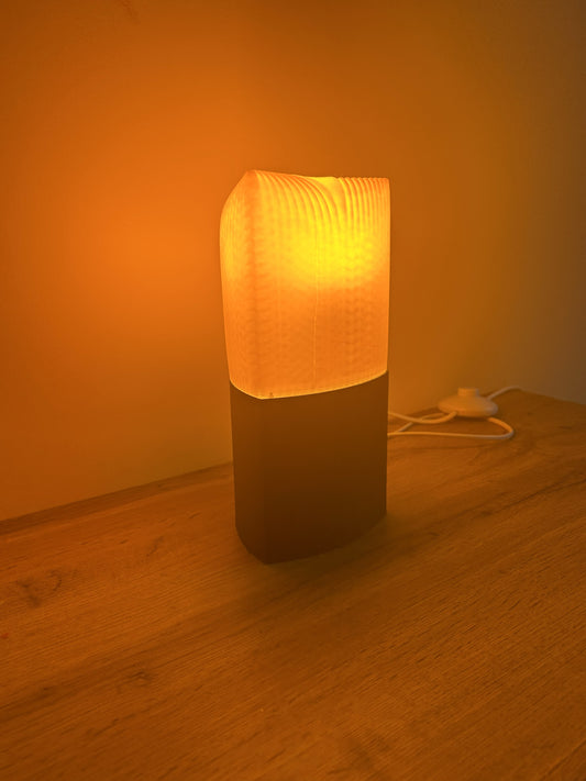 Lampada Lago Pogradec da tavolo stampata in 3D in PLA con lampadina accesa, luce calda e design moderno