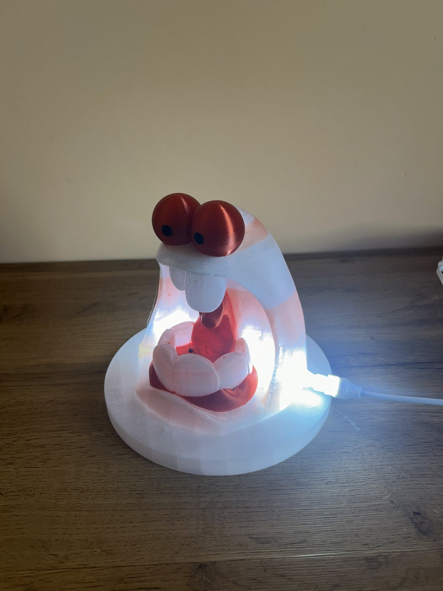 Lampada Paurosa con luce LED accesa, vista laterale che evidenzia l’effetto luminoso e il design originale