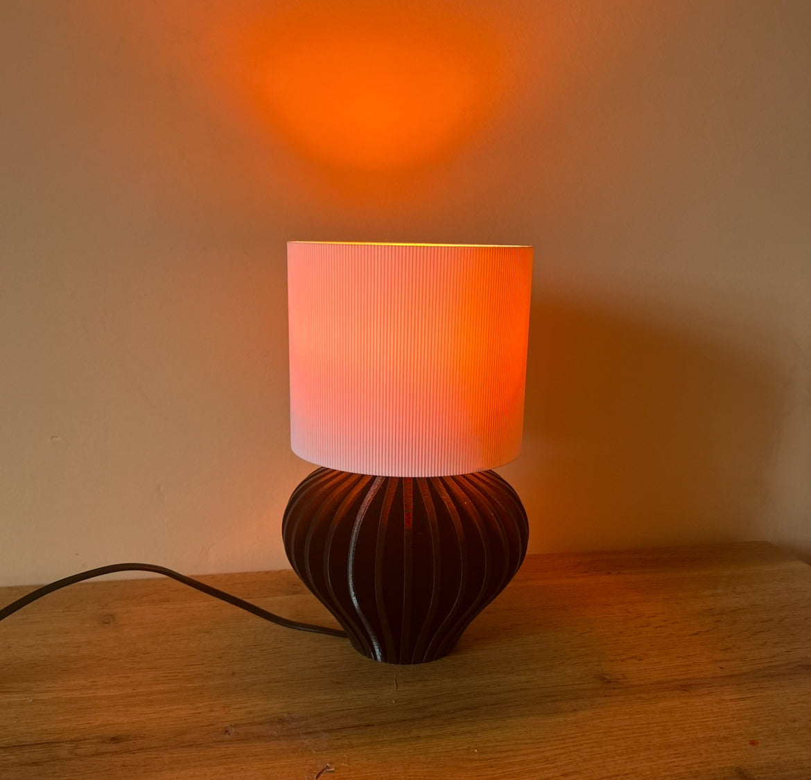 Lampada Pesca Noce accesa con luce calda, paralume diffondente e base design stampata in 3D