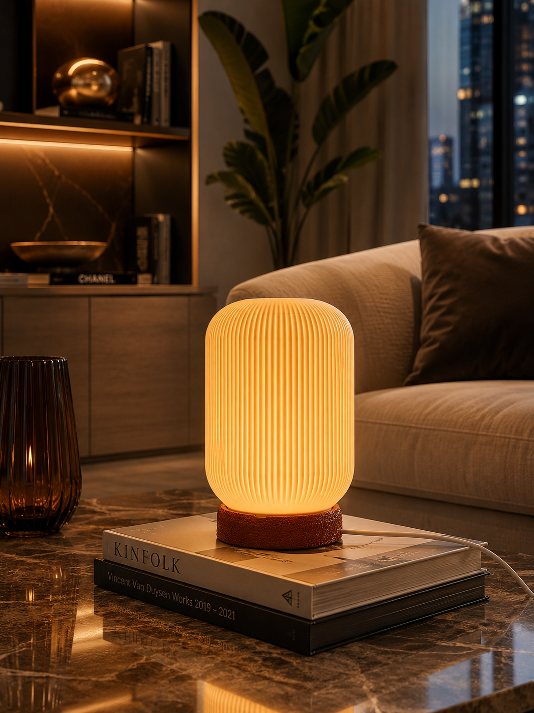 Warm glowing designer table lamp styled in a luxurious contemporary living room. The ribbed shade creates soft atmospheric illumination, making it an elegant accent light for living rooms, bedrooms, reading corners and modern interiors.