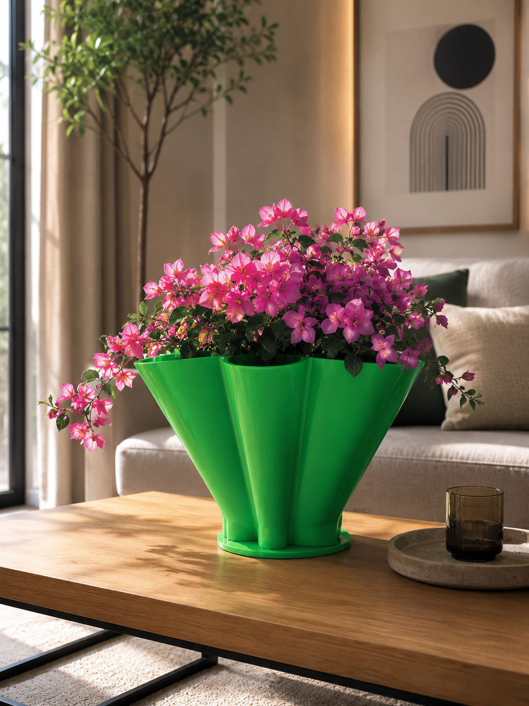 Modern geometric green flower pot filled with vibrant pink flowers inside a luxury Scandinavian living room. Decorative designer planter for elegant home decoration.