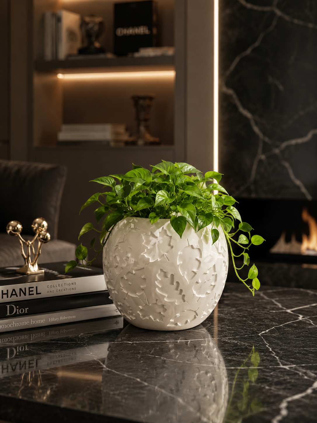 Luxury white designer planter with lush green pothos plant on a black marble coffee table in a modern living room with elegant contemporary interior decor.