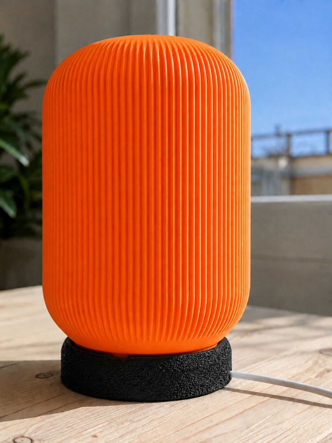 Modern 3D printed table lamp with a vibrant orange ribbed shade and textured black base, featuring a contemporary designer style for bedrooms, bedside tables, living rooms and modern home decor.
