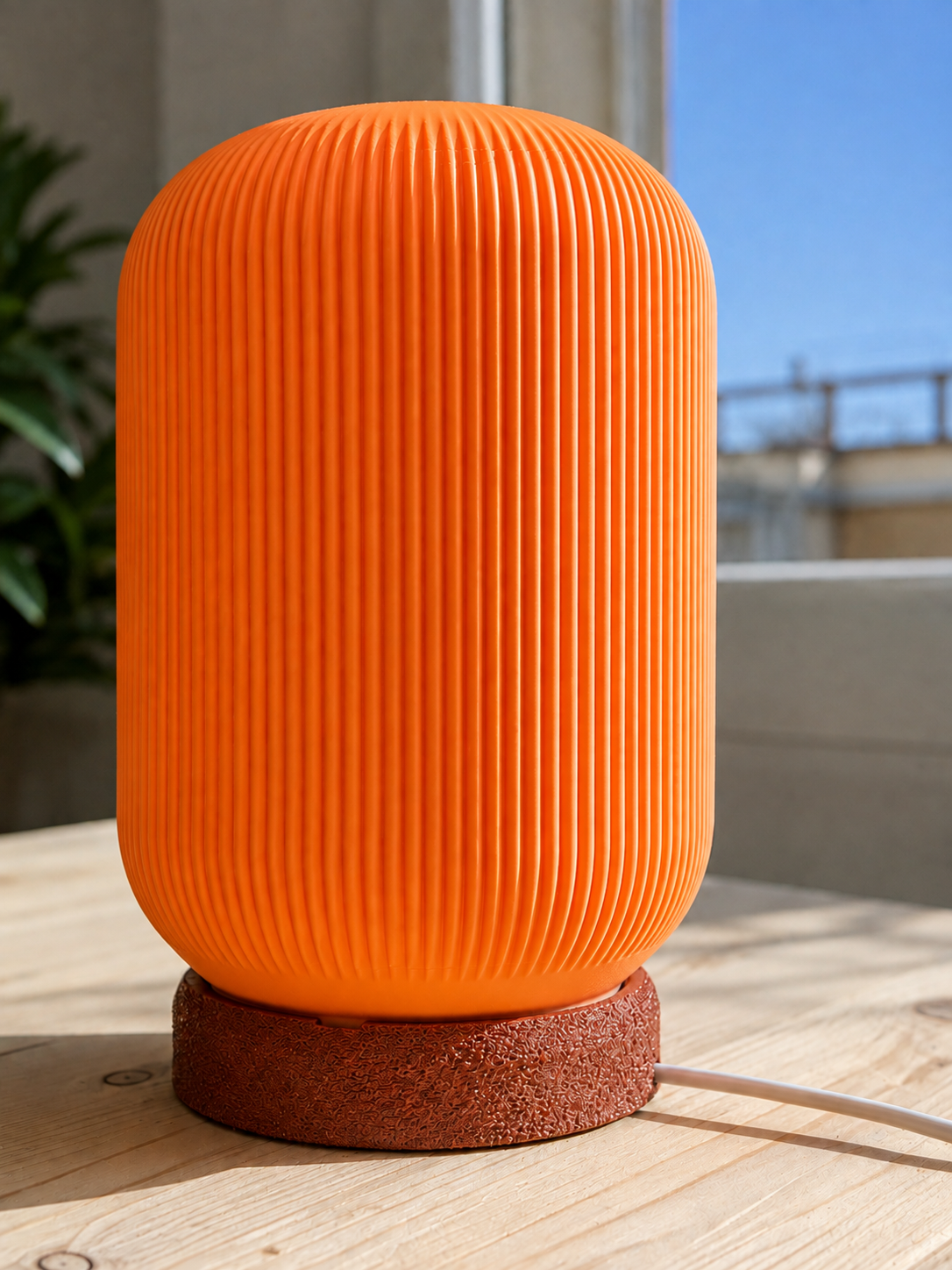 Modern 3D printed table lamp with a vibrant orange ribbed shade and textured brown base, featuring a contemporary designer style for bedrooms, living rooms, bedside tables and modern home decor.