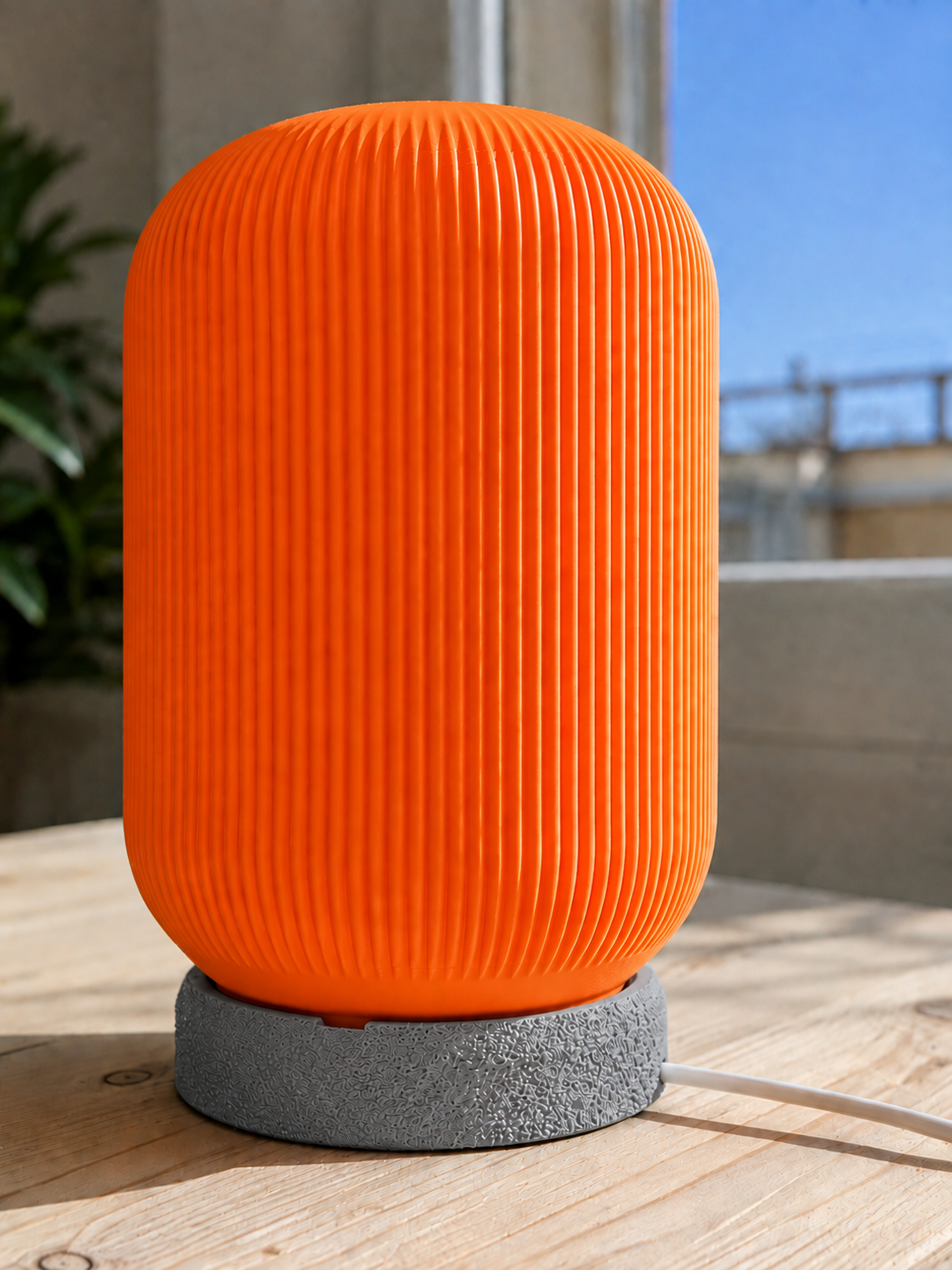 Modern 3D printed table lamp with a vibrant orange ribbed shade and textured grey base, featuring a contemporary designer style for bedrooms, bedside tables, living rooms and modern home decor.