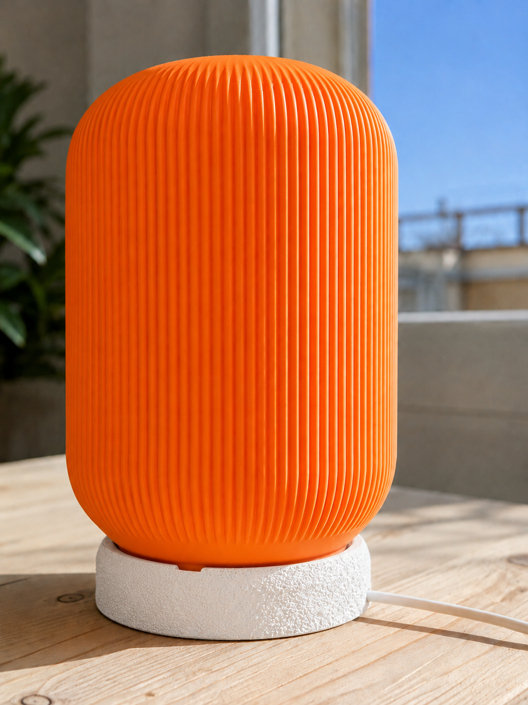 Modern 3D printed table lamp with a vibrant orange ribbed shade and textured white base, featuring a contemporary designer style for bedrooms, bedside tables, living rooms and modern home decor.