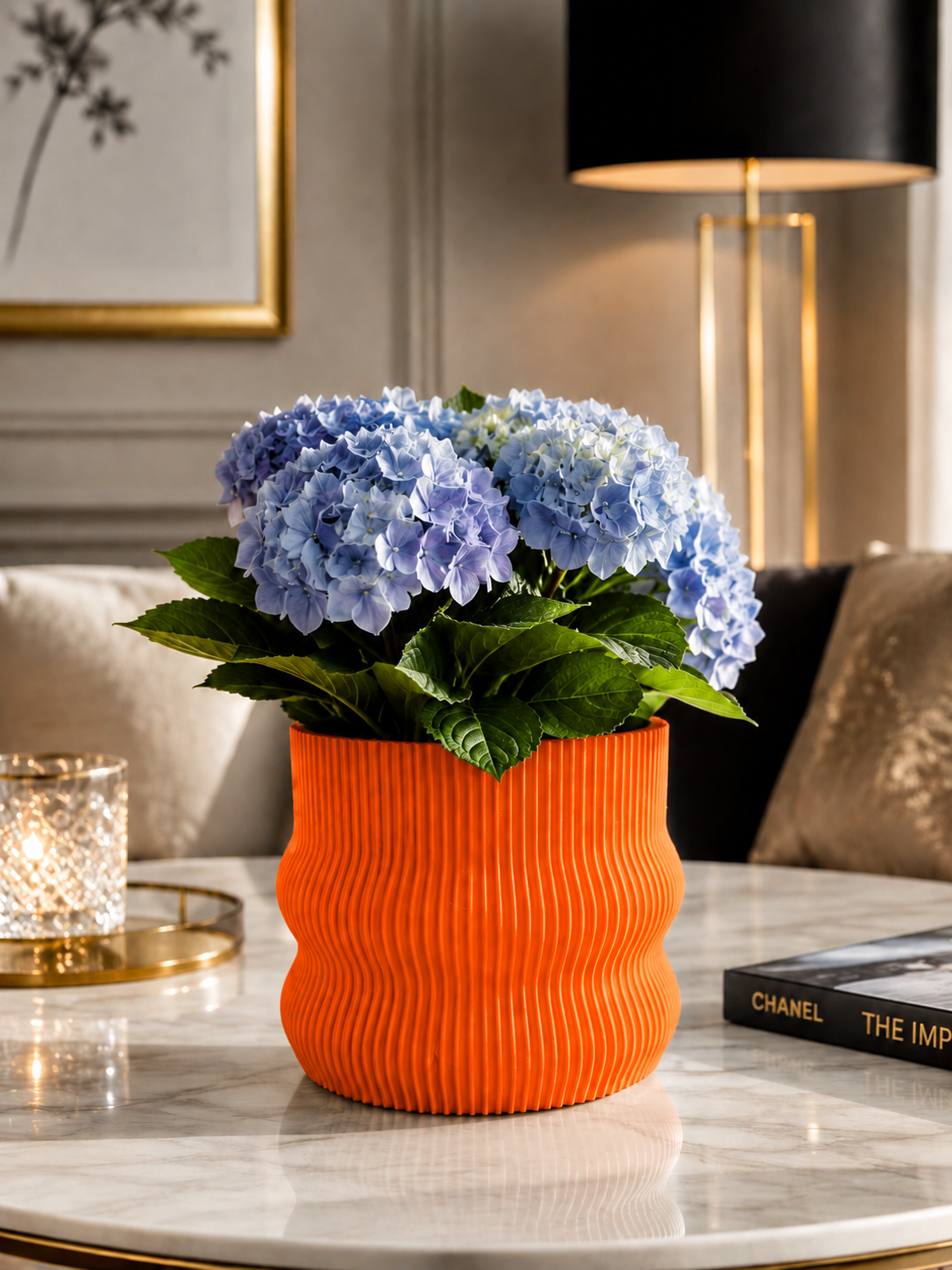 Elegant orange 3D printed planter crafted from premium PETG with a refined ribbed design. Decorative indoor plant pot featuring stunning blue hydrangeas, perfect for luxury home décor, modern living rooms, Scandinavian interiors, contemporary office styling, designer spaces, minimalist home decoration and premium interior design. Expertly designed and proudly made in Italy.