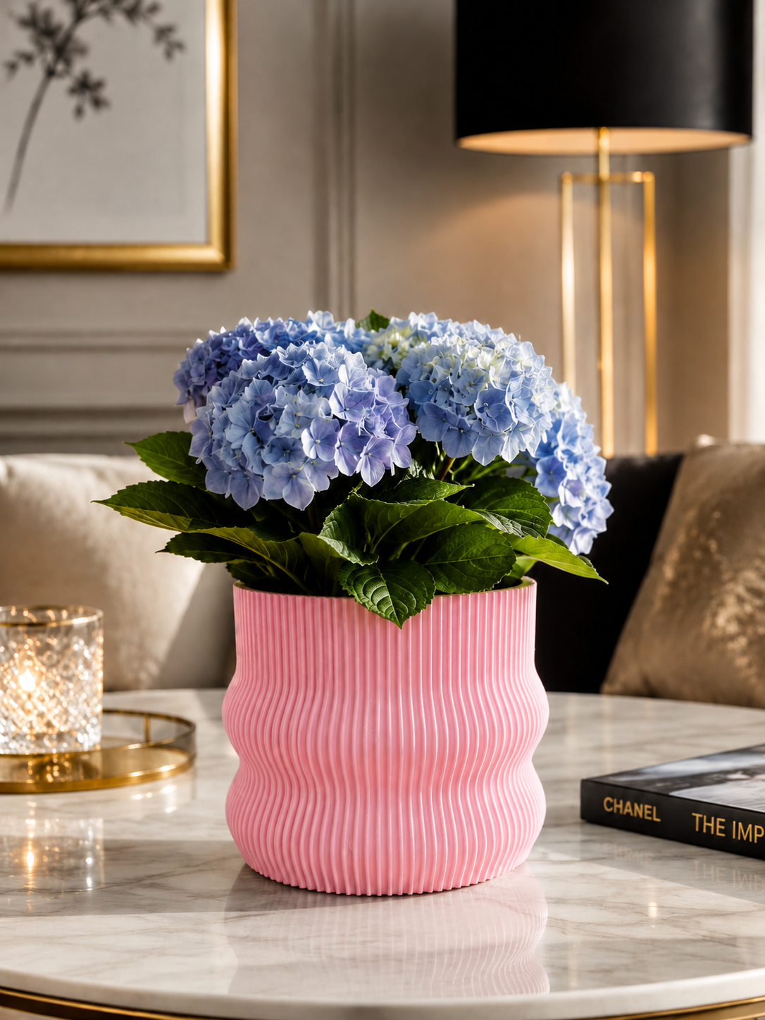 Elegant pink 3D printed planter crafted from premium PETG with a contemporary ribbed design. Decorative indoor plant pot featuring beautiful blue hydrangeas, perfect for luxury home décor, modern living rooms, Scandinavian interiors, office decoration, designer spaces and minimalist home styling. Expertly designed and proudly made in Italy.