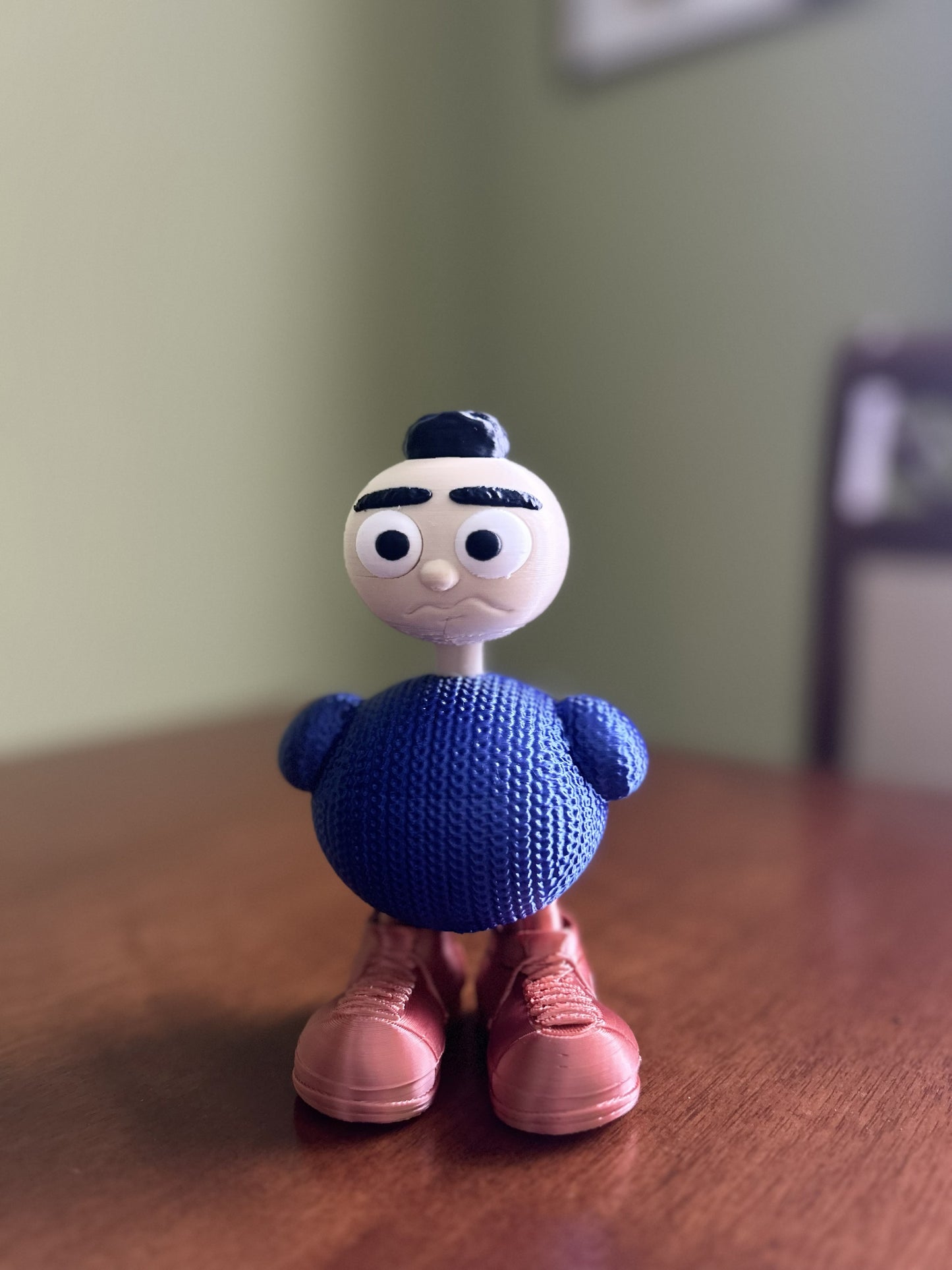 Nonnina Fjoccolosa personaggio decorativo stampato in 3D in PLA, corpo effetto maglia blu e scarpe color rame.