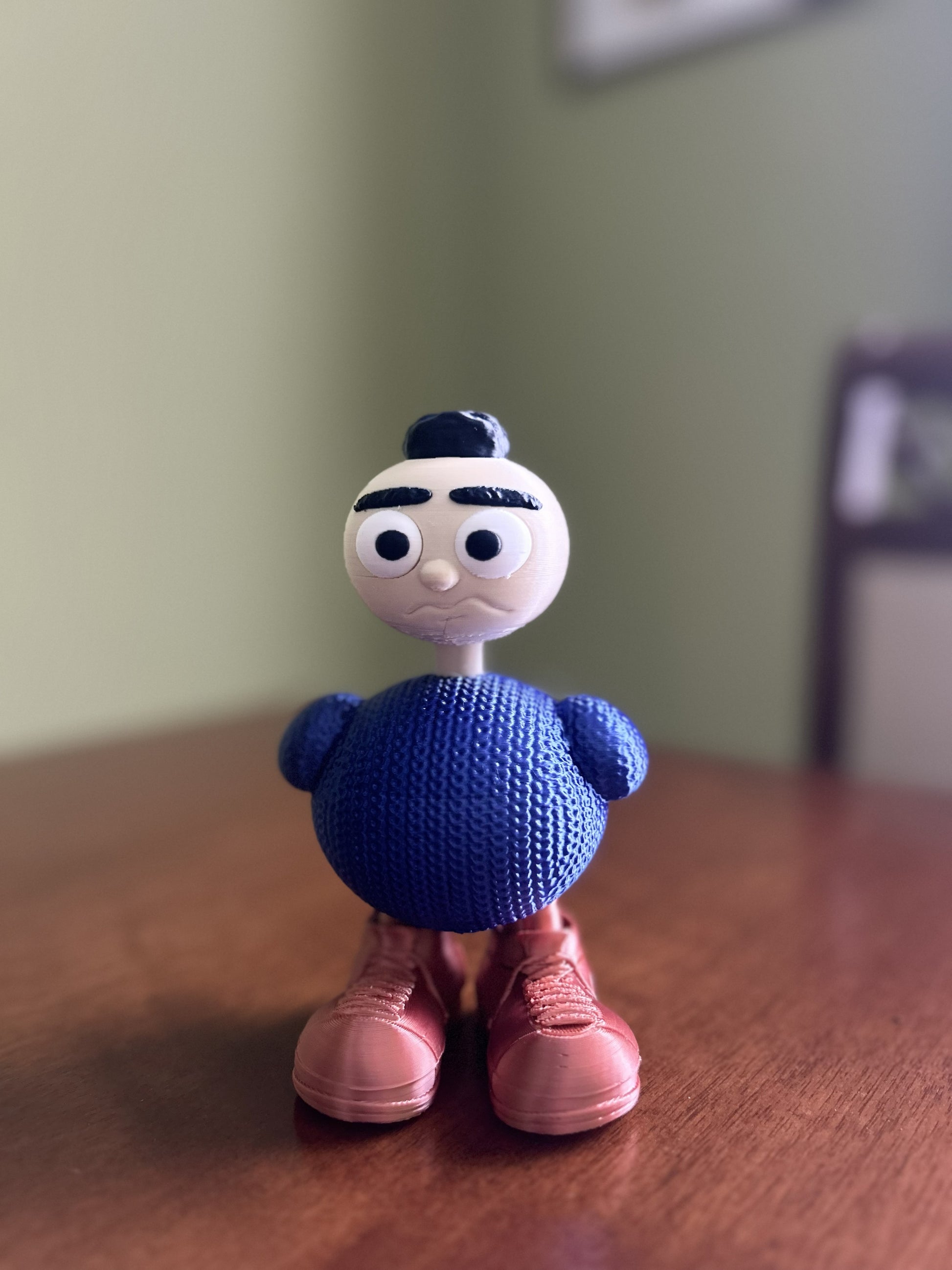 Nonnina Fjoccolosa personaggio decorativo stampato in 3D in PLA, corpo effetto maglia blu e scarpe color rame.