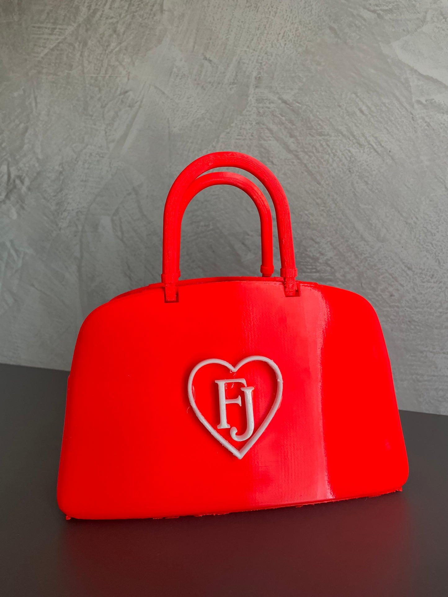 Red designer-inspired popcorn holder bag used in a movie theater, perfect for snacks, candy storage, cinema nights and modern home decor.