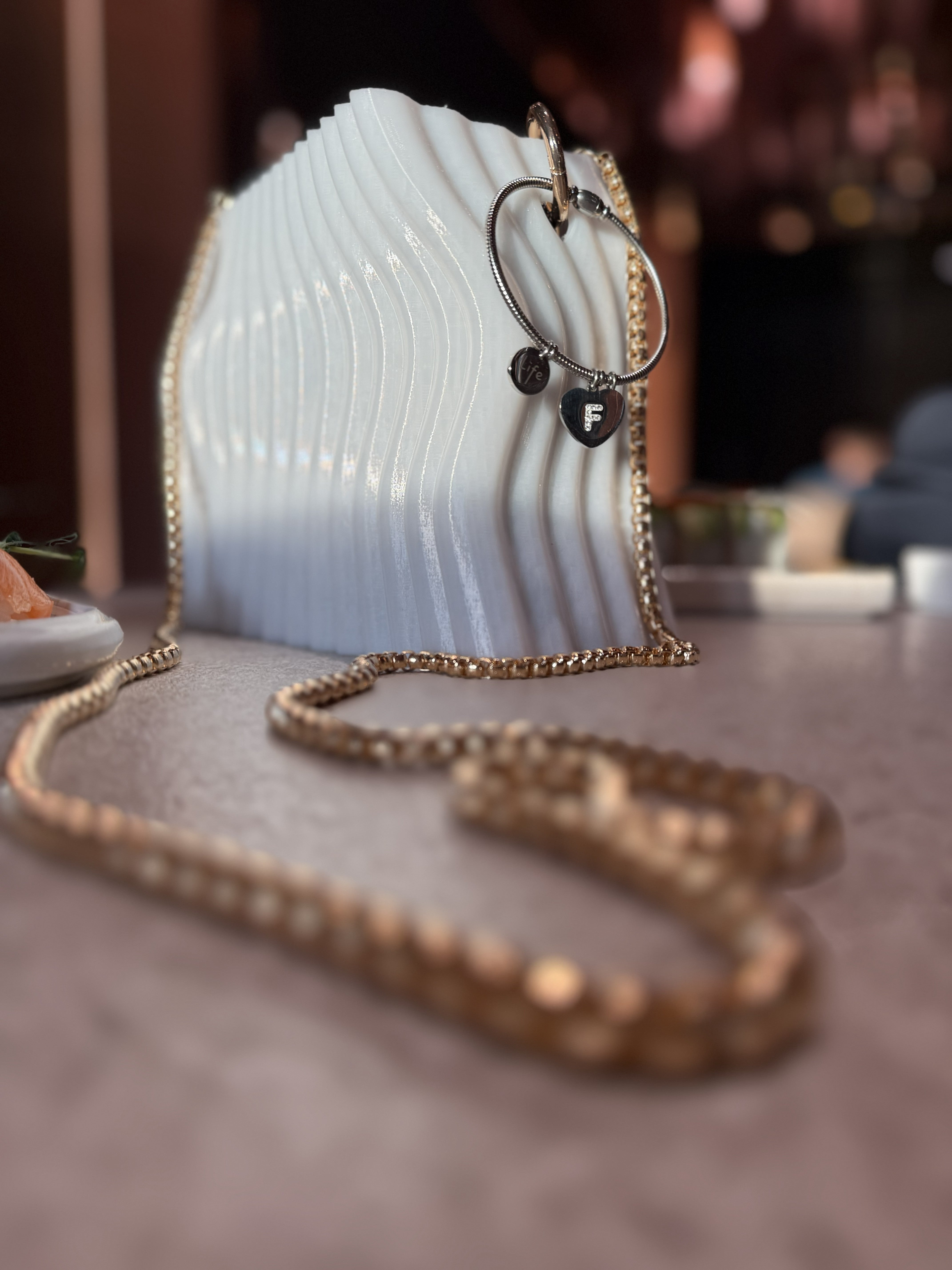 vista laterale borsa Urban Pearl in PETG con linee ondulate e design scultoreo moderno