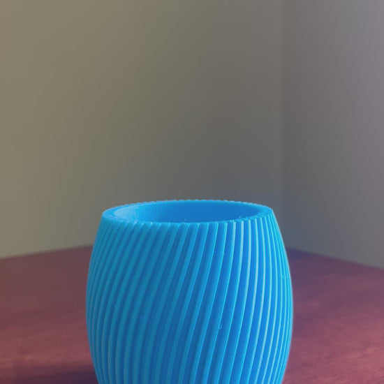 Elegant blue designer planter pot showcasing modern curved design, perfect for indoor plants, flowers, home decor, contemporary interiors and luxury living spaces.